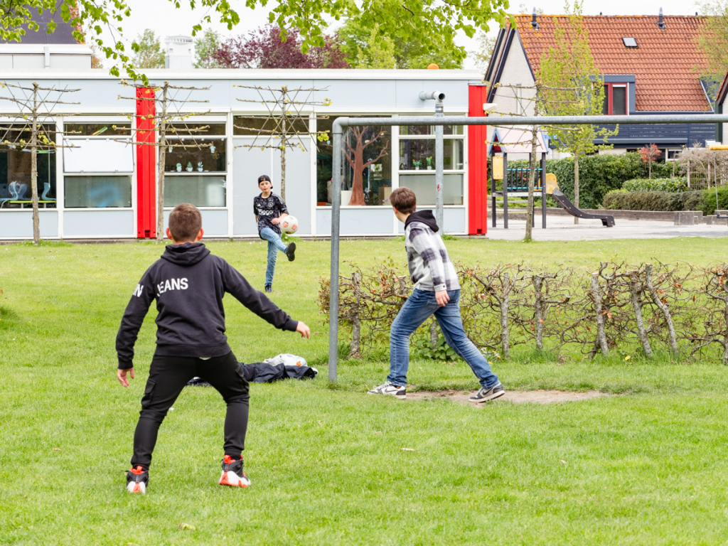 Jongens voetballen op een trapveldje